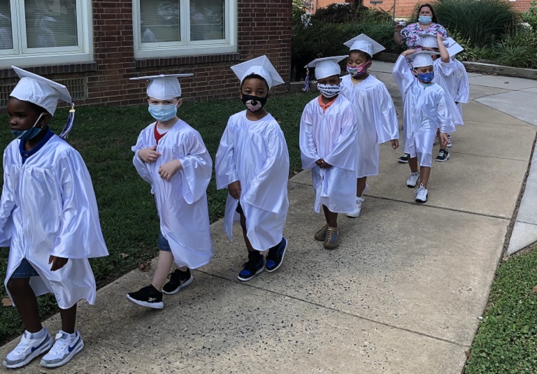 A group of children in graduation caps and gowns.